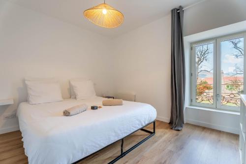 a bed in a room with a large window at Le Saphir By Clem in Pélussin