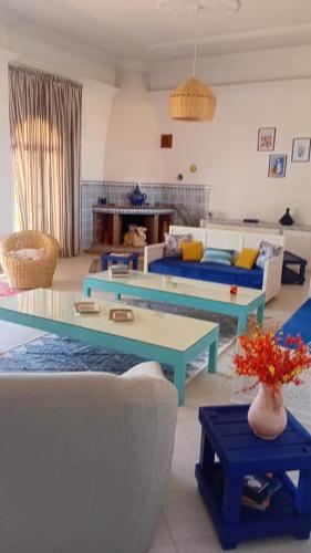 a living room with two couches and a table at Les jardins bleus in Taroudant