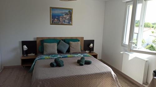 a bedroom with a bed with two teddy bears on it at Chambre privée in Montaigu-Vendée