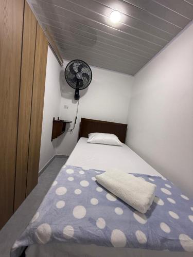 a bedroom with a bed and a fan at Hostal Ruta Cafetera in La Tebaida