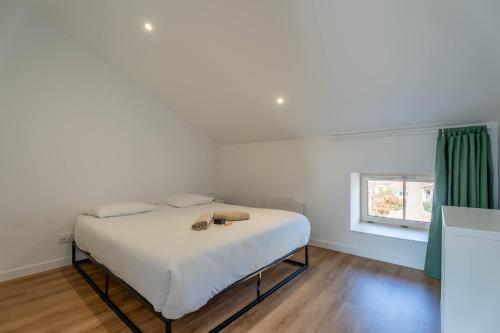 a white bed in a room with a window at L'Emeraude By Clem in Pélussin