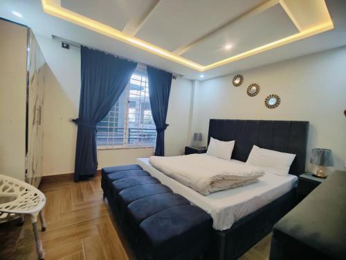 a bedroom with a large bed and a blue couch at Snow Stones in Khaira Gali