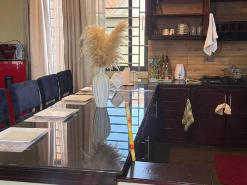 a glass table with a vase on top of it at Nady Apartment in Dodoma