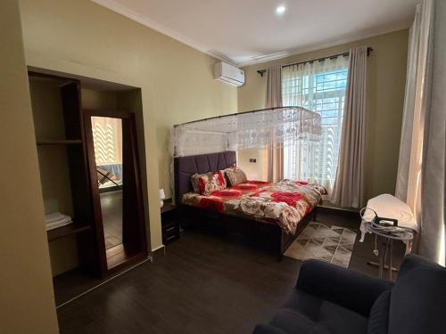 a bedroom with a bed and a large window at Nady Apartment in Dodoma