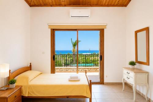 a bedroom with a bed and a view of the ocean at Villa Chrisandria in Argaka