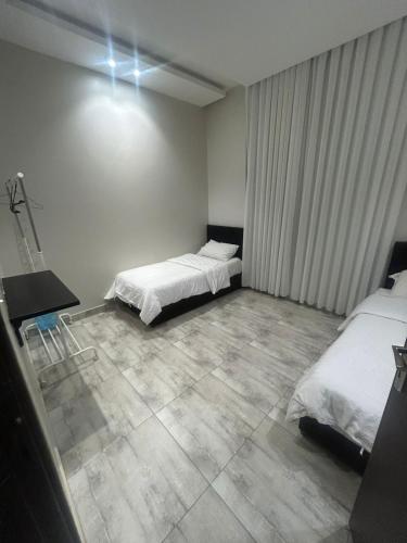 a bedroom with two beds and a tiled floor at شاليهات موج لاند 1 in Taif