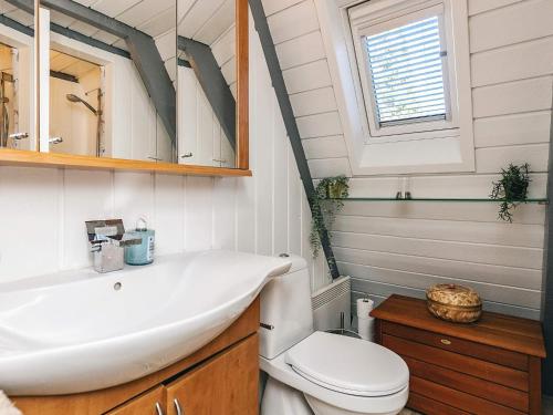 a bathroom with a sink and a toilet and a mirror at Himmerland Stay, Golf & Spa in Farsø