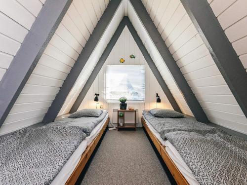 two beds in a pitched room with a window at Himmerland Stay, Golf & Spa in Farsø