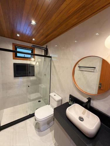 a bathroom with a toilet and a shower and a sink at Chalé das Pedras - Domingos Martins in Domingos Martins
