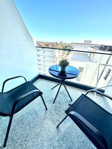 a table and two chairs on a balcony with a view at Apartamente & Studiouri Melia Eforie Nord in Eforie Nord
