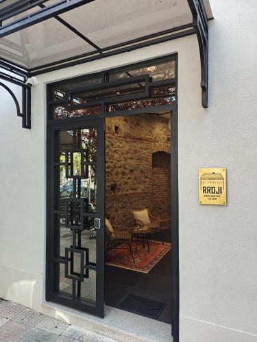 an open door to a patio with a chair inside at Rroji Urban Heritage - Boutique Rooms & Serviced Apartments in City Center in Shkodër