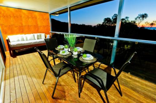 a black table and chairs on a balcony with a couch at Wine Down in Agnes Water