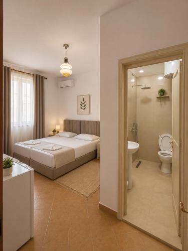 a bedroom with a bed and a bathroom with a toilet at Vacation house villa roni in Durrës