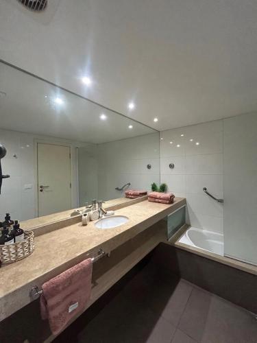 a bathroom with a sink and a tub and a mirror at MySuites in Montevideo