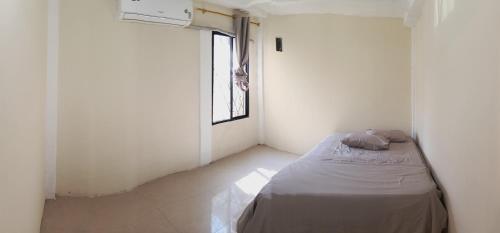 a bedroom with a bed in a room with a window at El delfín Santa Elena -Salinas in Santa Elena