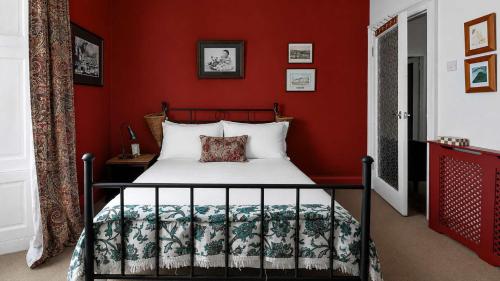 a bedroom with a bed with red walls at Williams Haven in Rothesay