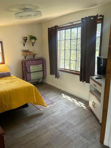 a bedroom with a yellow bed and a window at Swift Hollow Timeless Memories in Mountain City