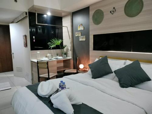 a bedroom with a large white bed and a table at Estor Staycation in Manila