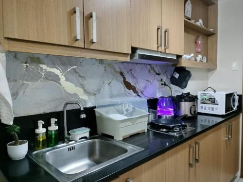 a kitchen with a sink and a counter top at Estor Staycation in Manila