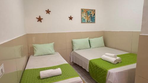 two beds in a room with green and white at Pousada Farol do Porto Nova ADM 2026 in Porto De Galinhas
