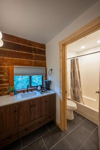 a bathroom with a sink and a toilet and a tub at The Woodsman Lodge in Eureka Springs