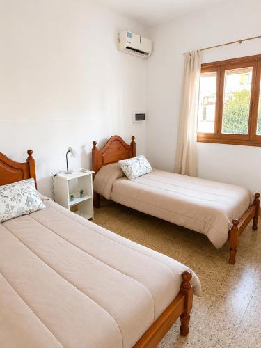 a bedroom with two beds and a window at Alojamiento Uruguay in Santa Rosa
