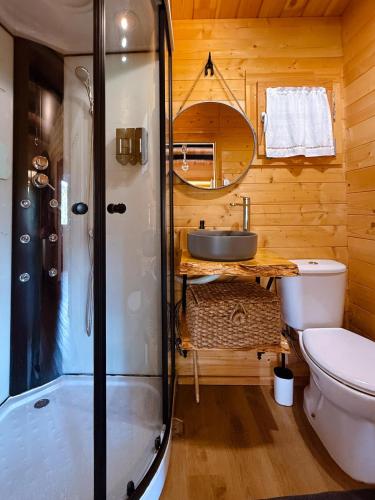 a bathroom with a shower and a toilet and a sink at Ohana Gerês House in Ruivãis