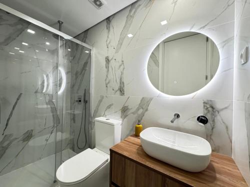 a bathroom with a sink and a toilet and a mirror at Ribeira do Forno 2 in Adaúfe