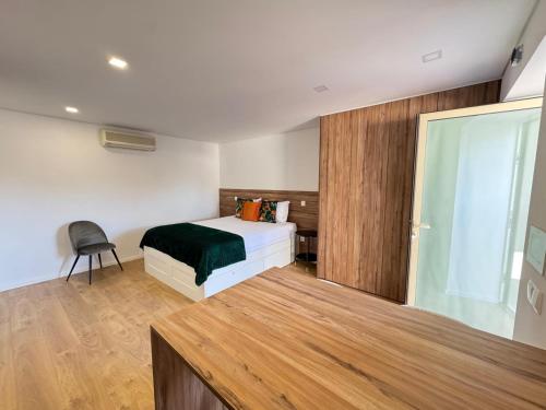 a bedroom with a bed and a sliding glass door at Ribeira do Forno 2 in Adaúfe