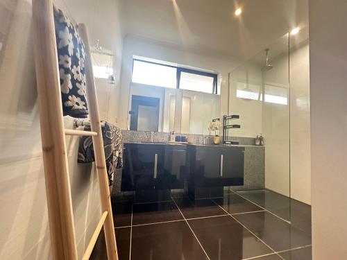 a bathroom with a sink and a mirror at La Maison Barwon in Connewarre