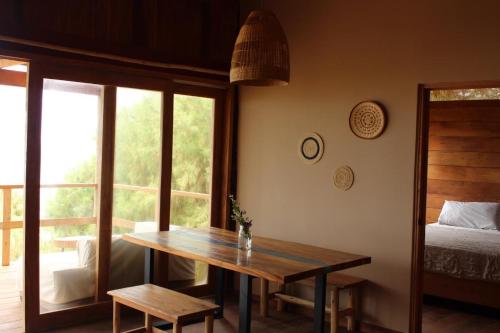 a room with a table and a bed and a window at Las tortugas bungalow in Vichayito