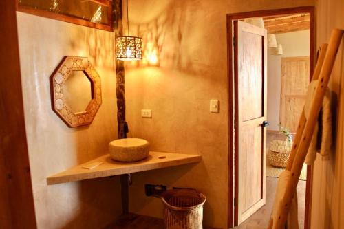 a bathroom with a sink and a mirror on a wall at Las tortugas bungalow in Vichayito