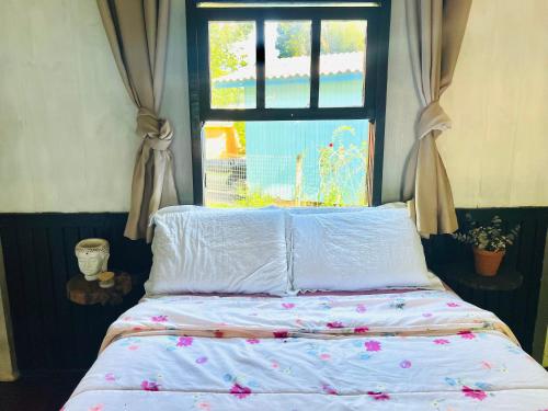 a bed in a room with a window at Casa Centenária com 20 min de Gramado in Três Coroas