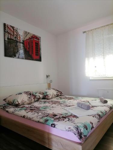 a bed in a white room with a picture on the wall at Apartment Ivy2 in Lovran