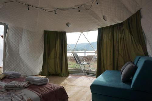 a bedroom with a bed and a couch and a window at Glamping Krupac Lake in Blaca