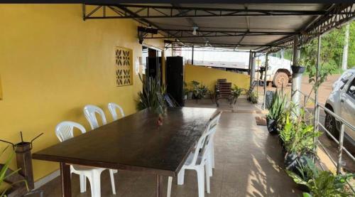 a table and white chairs on a patio at Pousada recanto da fronteira in Oiapoque