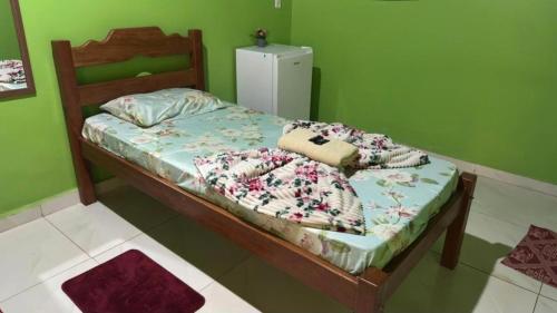 a bedroom with a bed with a green wall at Pousada recanto da fronteira in Oiapoque