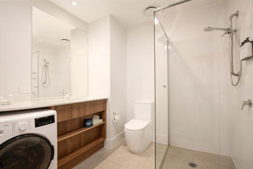a bathroom with a washing machine and a toilet at Durham Serviced Apartments in Adelaide