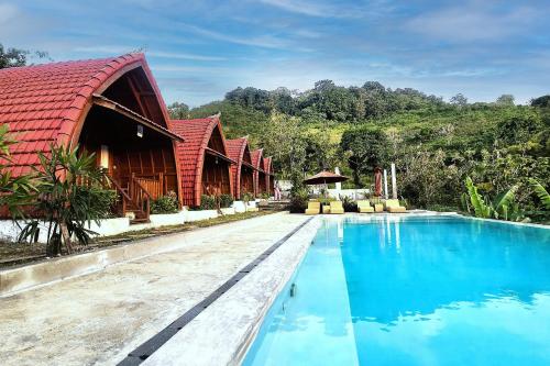 a resort with a pool and a red roof at Dudu Cottage Nusa Penida in Nusa Penida