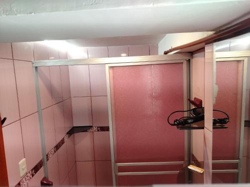 a bathroom with pink walls and a red door at Cusco Tahuanwasi Apartments in Cusco