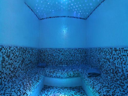 a room with a bath tub with blue lights at Park Hotel Mater Dei in Pozza di Fassa