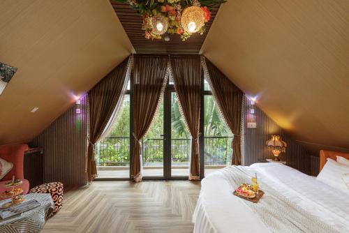 a bedroom with a bed and a large window at Up Tree Garden Đà Lạt in Xuan An