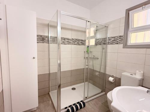 a bathroom with a shower and a toilet and a sink at Cozy holyday apartament in Paralimni