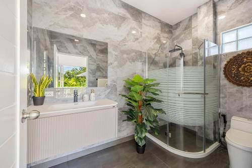 a bathroom with a shower and a sink and a toilet at Villa Kiru in Koh Samui