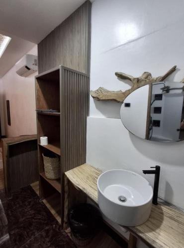 a bathroom with a white sink and a mirror at Sand 1 Hostel in Siquijor