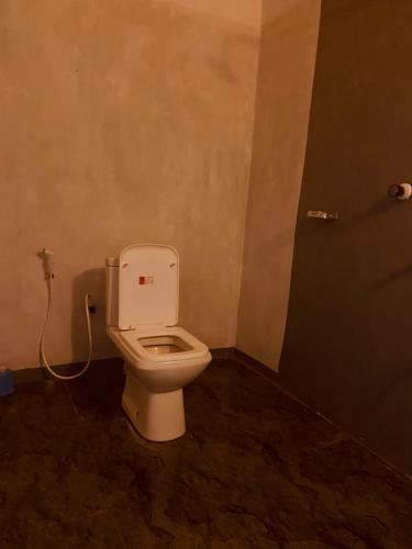 a bathroom with a white toilet in a room at KR Villa in Arugam Bay