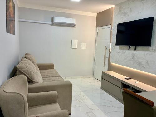 a living room with a couch and a flat screen tv at Apto novo prox Parque Thermal e centro de evento in Piratuba
