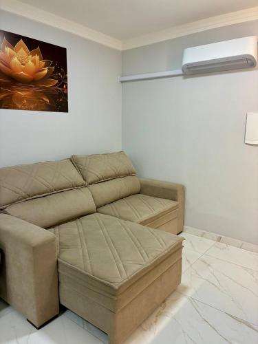 a living room with a couch and a painting on the wall at Apto novo prox Parque Thermal e centro de evento in Piratuba