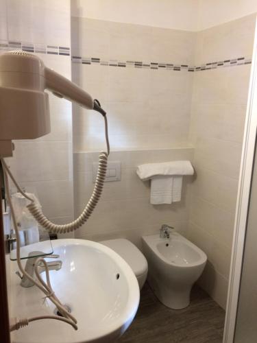 a bathroom with a sink and a toilet and a lamp at Twelve Hotel in Moncalieri
