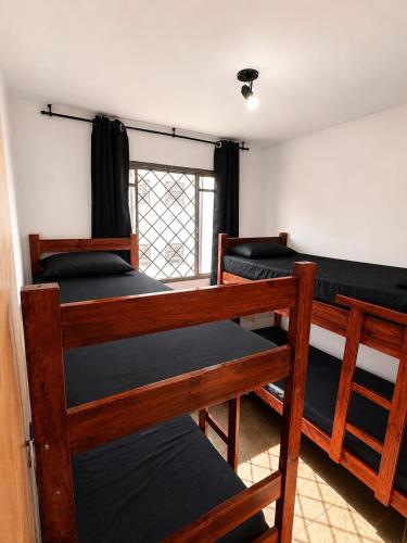 a room with three bunk beds and a window at Apartamento Residencial Alice in Uberaba